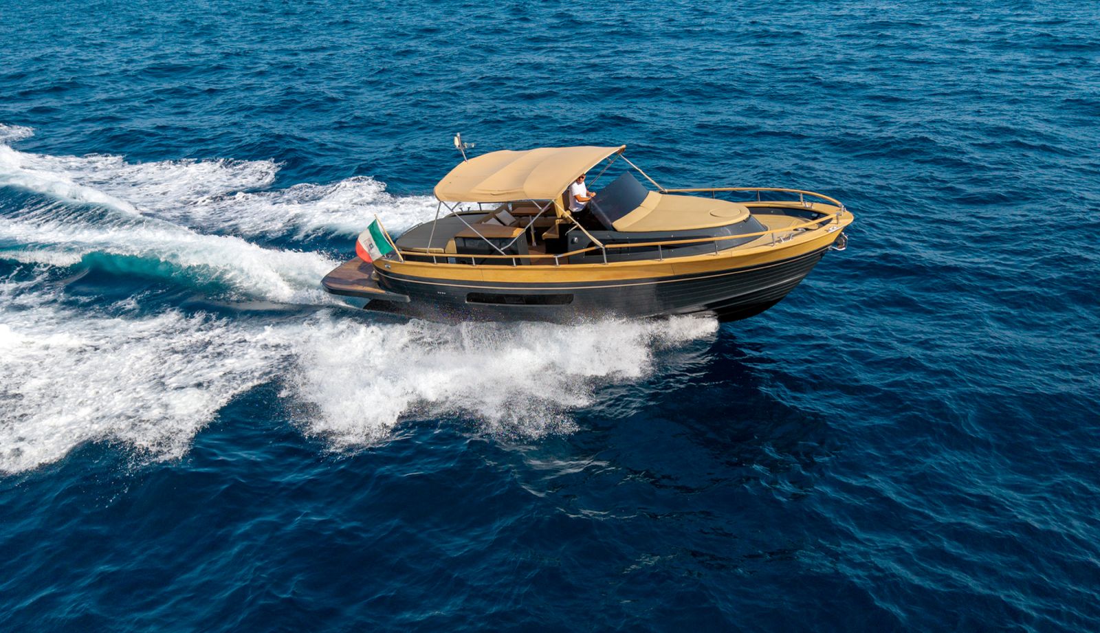 Il gozzo in navigazione veloce con bandiera italiana